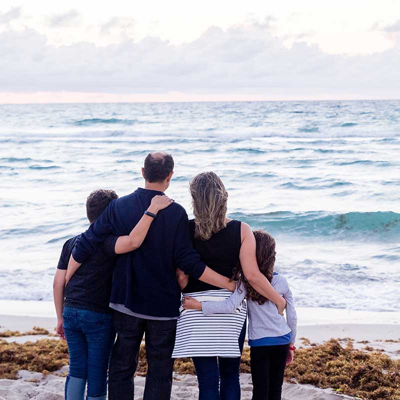 A family gaze across an ocean towards a sunset after a successful counselling session at Mates Matter Counselling