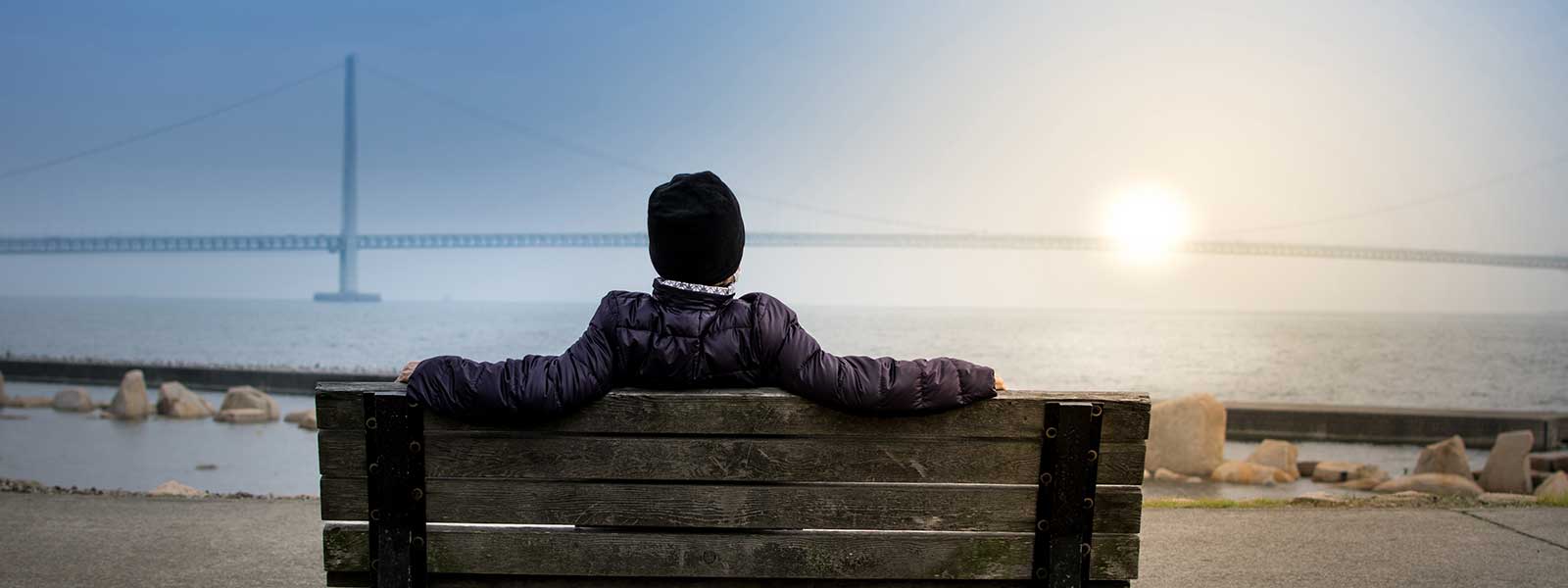 A person stares pensively at a bridge over open waters before their session with Mates Matter Counselling